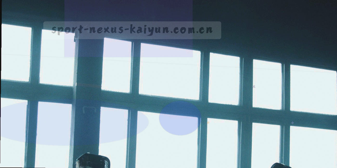 黄昏逆光下看台一角与远处球场灯剪影，画面留白较多